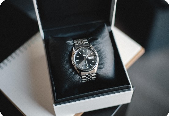 A steel wristwatch in an open presentation box